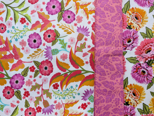 A close up photo of three floral prints from the White Zinnias Fabric bundle.