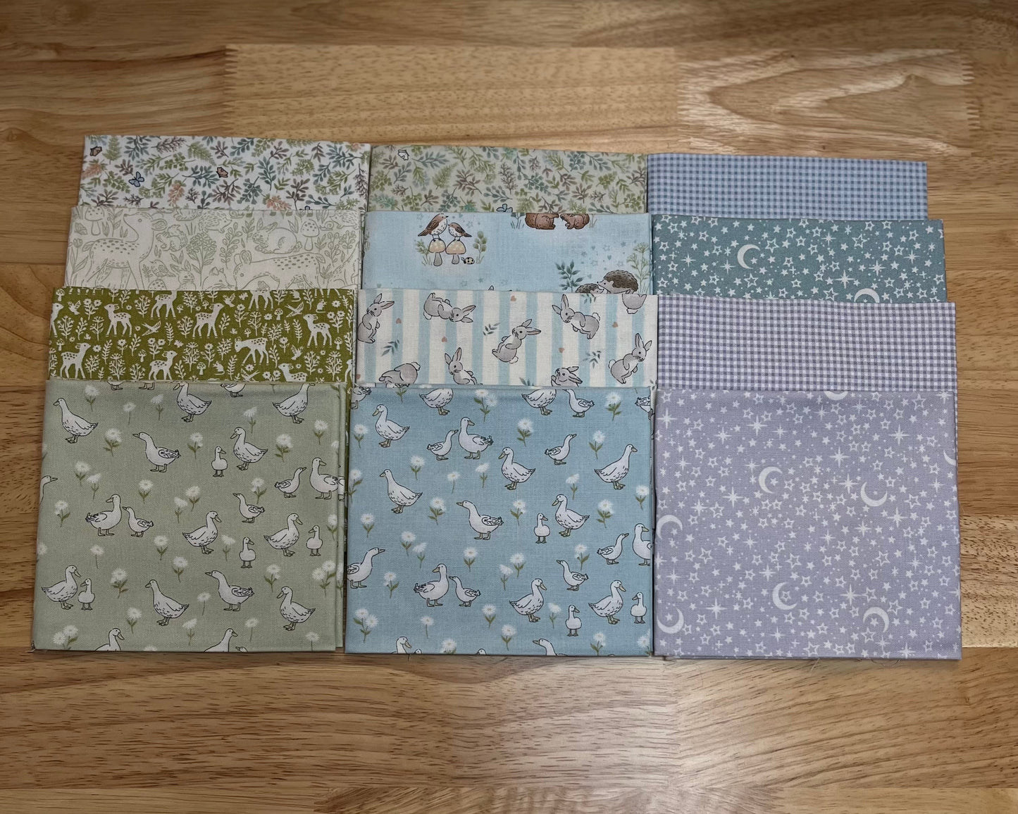 12 of the fabrics from the Little Ones collection from Makower UK and Andover come in charming teal, green, and grey shades, featuring moon and stars, leaves, birds, bunnies, deer, and ducks, and tiny gingham fabrics to match.