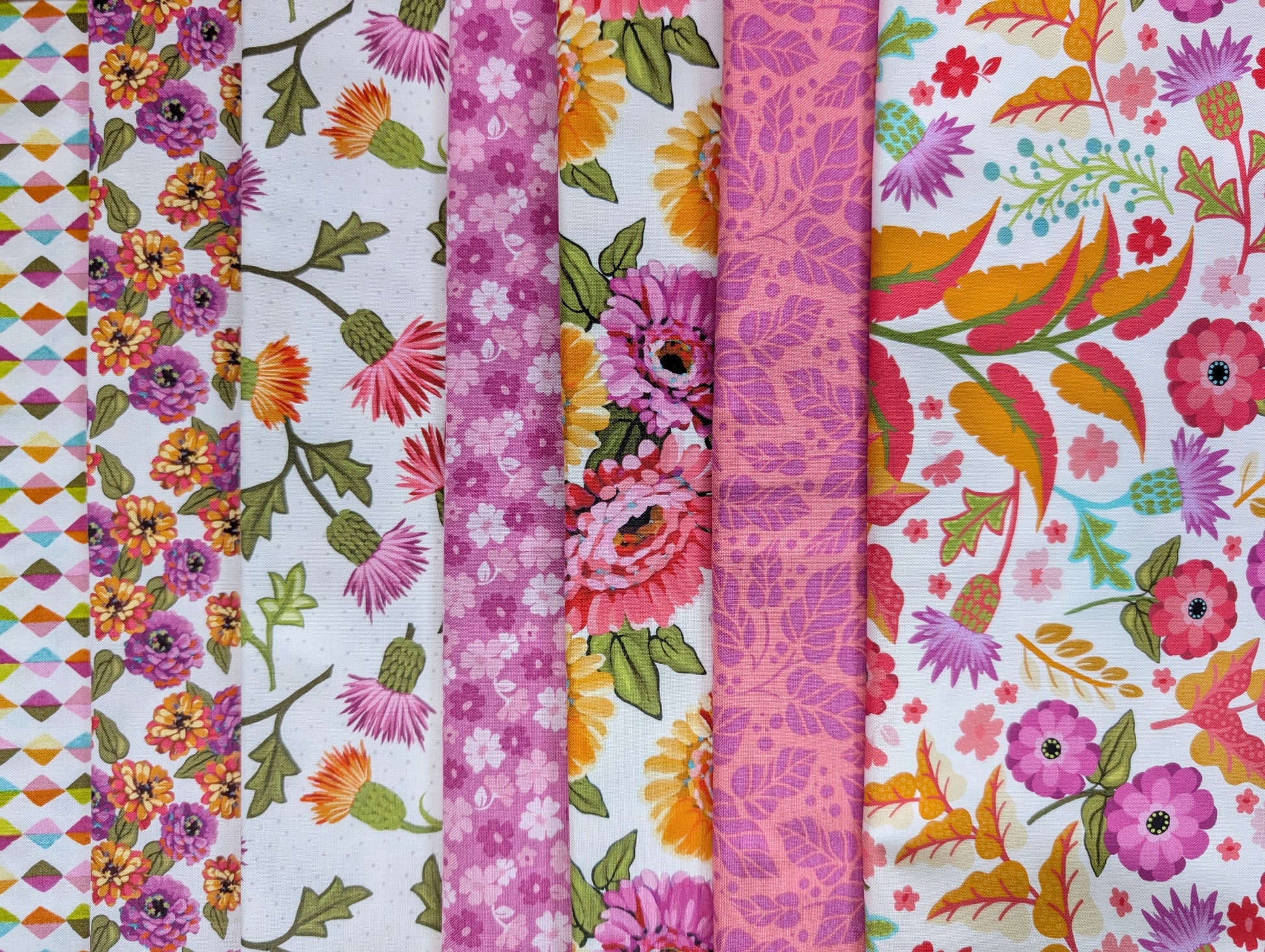 Seven brightly colored floral fabrics in pink and white inspired by the dazzling zinnia.